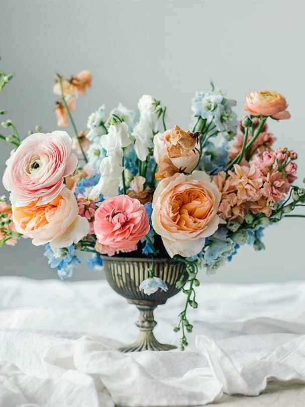 Centro de flores frescas en jarrón sobre mantel blanco en Floristería La Camelia de Vigo