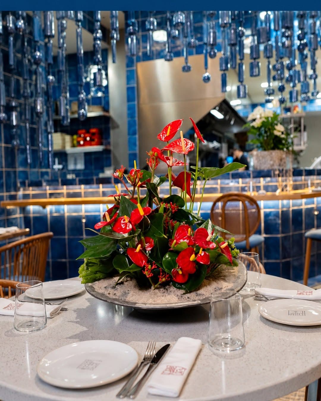 Centro floral de anturios rojos decorando la mesa de un restaurante en Vigo