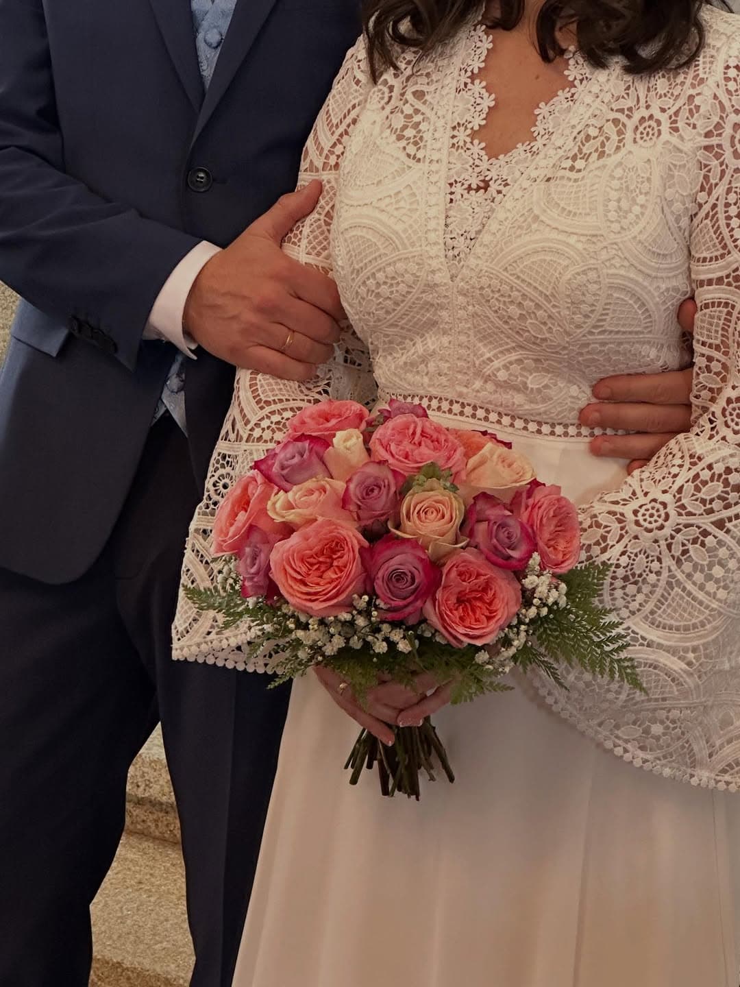 Novia sujetando su ramo de rosas en tonos rosados elaborado en la floristería de Vigo